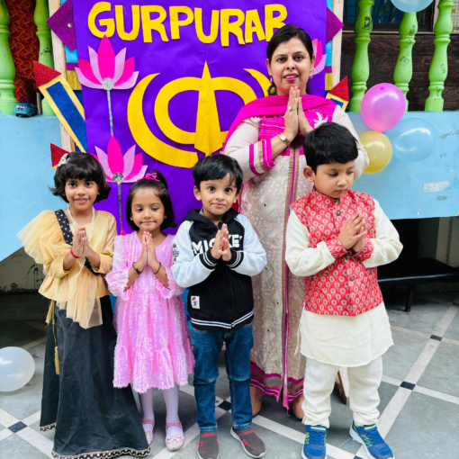 A joyful GurPurab celebration at Udayan Kidz Premium Preschool and Day Care Center, featuring a decorated background board themed for the occasion with a teacher and group of students standing in front.